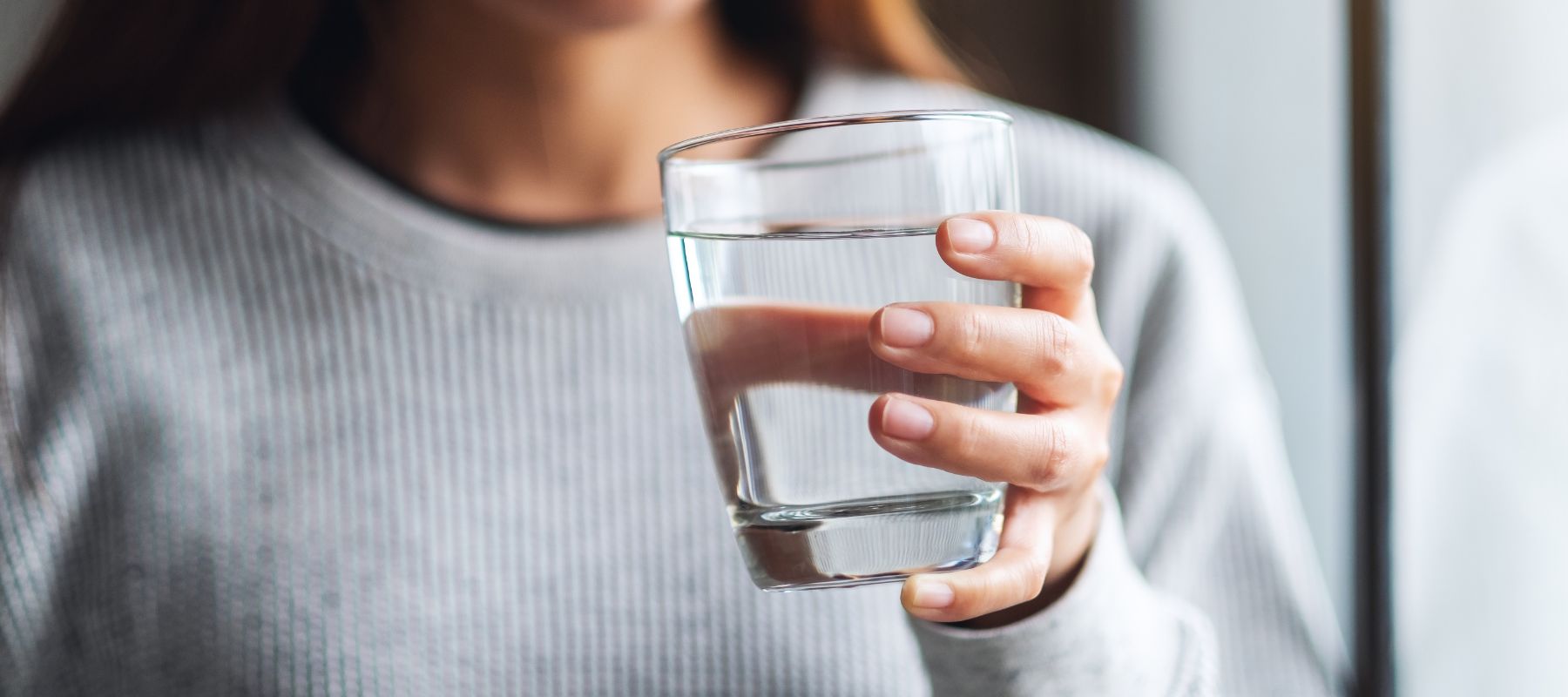 young woman holding a clean glass of water