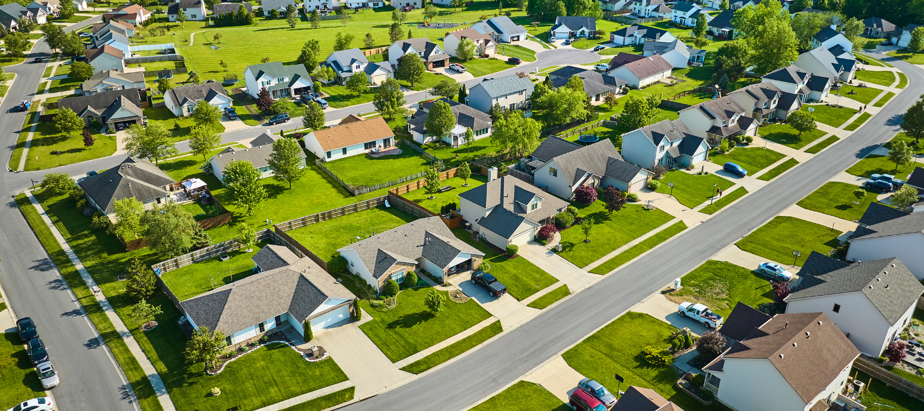 Aerial neighborhood with bright green summer lawns